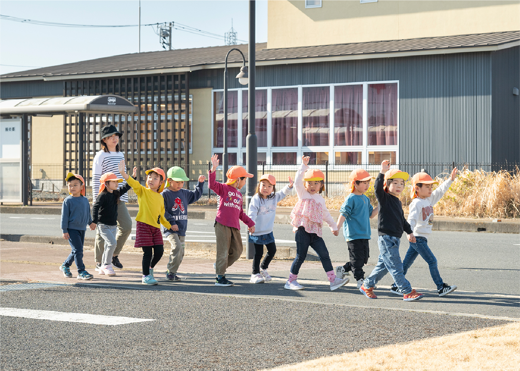 手を挙げて道路を渡る子供達