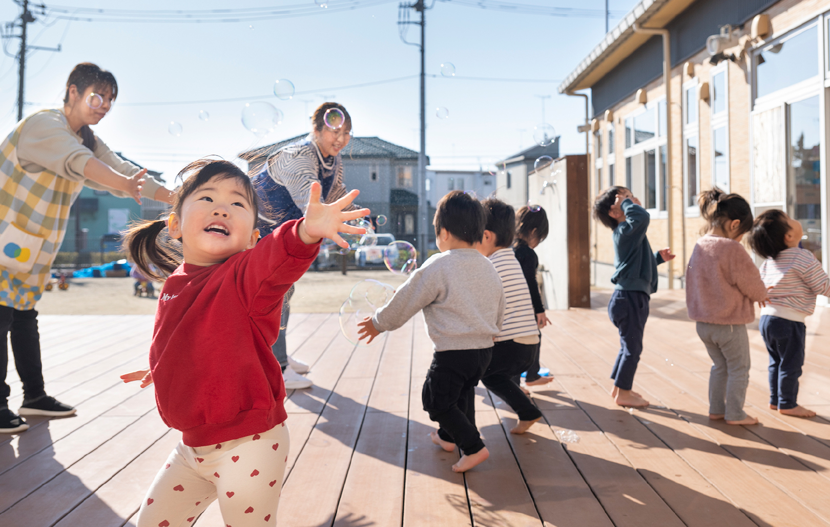 シャボン玉で遊ぶ園児